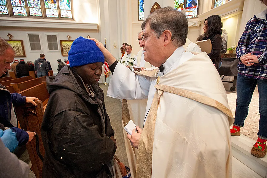 Fr. Cattany blesses an attendee of the annual Father Woody Christmas cash giveaway, Dec. 14, 2017.?w=200&h=150