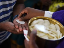 A priest distributes Holy Communion.