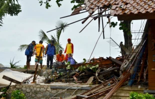 Officials look through the wreckage of damaged buildings in Carita, Indonesia on December 23, 2018.   AFP/Getty Images.