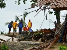 Officials look through the wreckage of damaged buildings in Carita, Indonesia on December 23, 2018. 