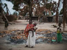 A woman stands in a burned out area after an extremist attack on the village of Aldeia da Paz, Mozambique, Aug. 24, 2019.