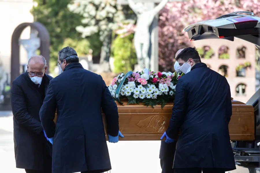 Undertakers wearing a face mask carry coffin in a cemetary in Bergamo, Italy on March 16, 2020. ?w=200&h=150