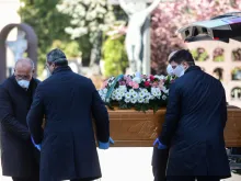Undertakers wearing a face mask carry coffin in a cemetary in Bergamo, Italy on March 16, 2020. 