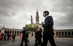 People wearing face masks carry the statue of Our Lady of Fatima at the shrine in Portugal May 13, 2020.   AFP via Getty Images