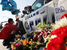 A man leaves a note at a makeshift memorial honoring the five police officers killed in a July 7 shooting in Dallas, Texas. 