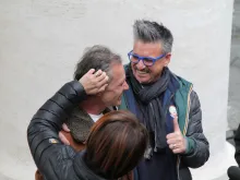 Volunteers embrace Polish homeless man Gregorio after he visits the Vatican's new shower and barbershop facilities. 