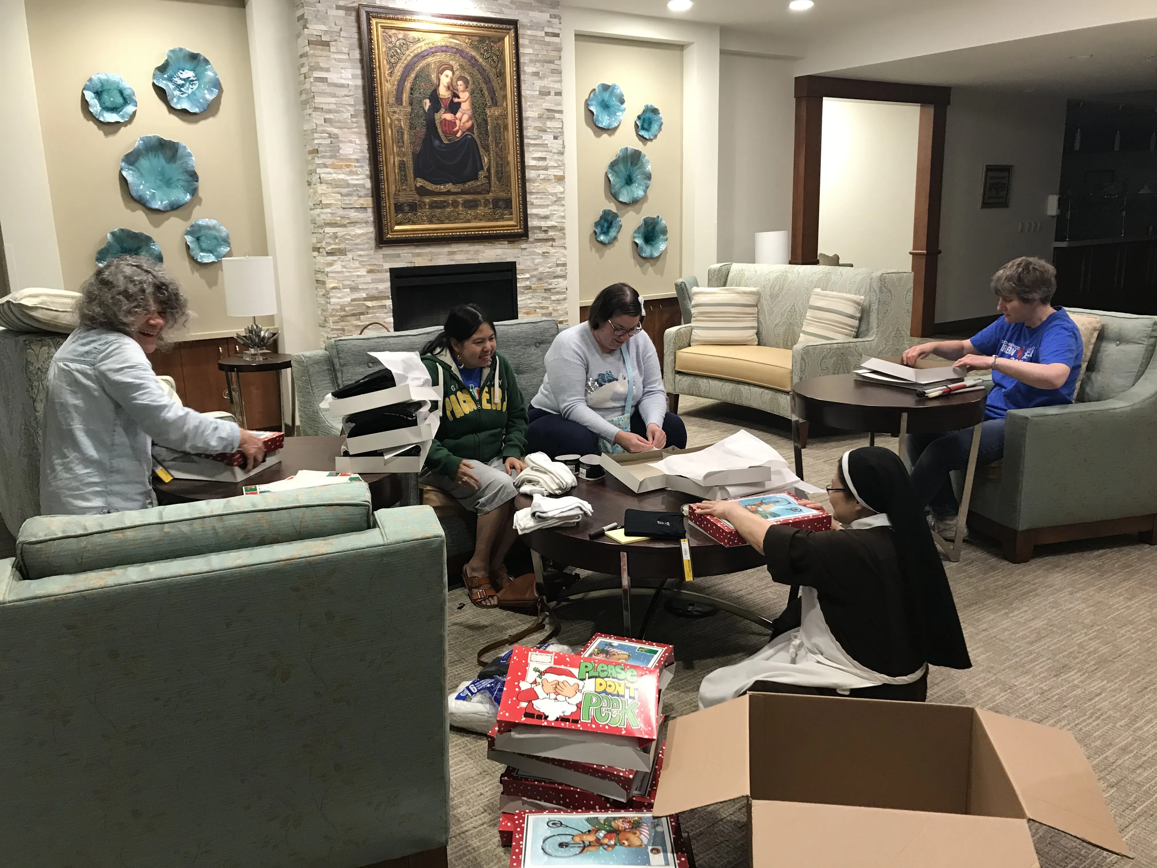 A religious sister and residents of the Carmelite Ministry of St. Teresa wrap gifts for veterans. Courtesy photo.?w=200&h=150