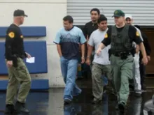 Immigrants are detained by sheriff's deputies outside of a DVD manufacturing company in Santa Clarita, Calif. in Feb. 2009. 
