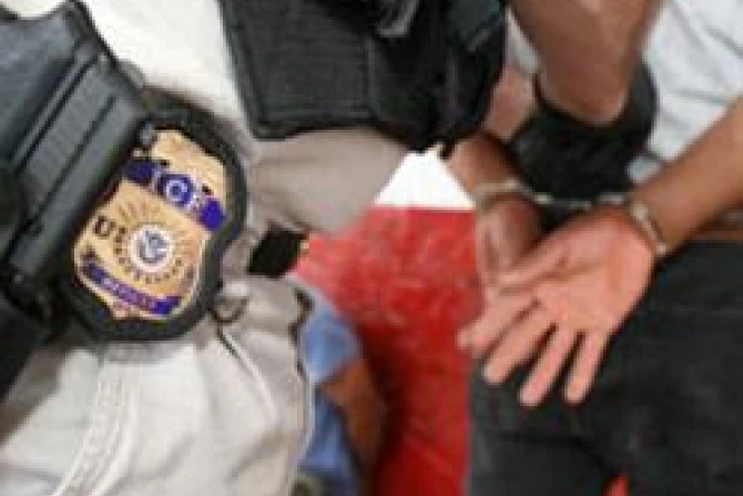 Immigrations and Customs Enforcement ICE Officer escorting a man in handcuffs CNA US Catholic News 8 19 11