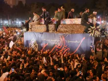 Iranians gather around the caskets of Qasem Soleimani and others during a funeral procession after the bodies arrived in Qom, Jan. 6, 2020. 