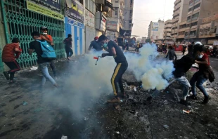 Iraqi protesters run from tear gas fired by security forces at Baghdad's Khallani square during ongoing anti-government demonstrations, Nov. 12, 2019.   Ahmad al-Rubaye/AFP via Getty Images.