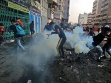 Iraqi protesters run from tear gas fired by security forces at Baghdad's Khallani square during ongoing anti-government demonstrations, Nov. 12, 2019. 
