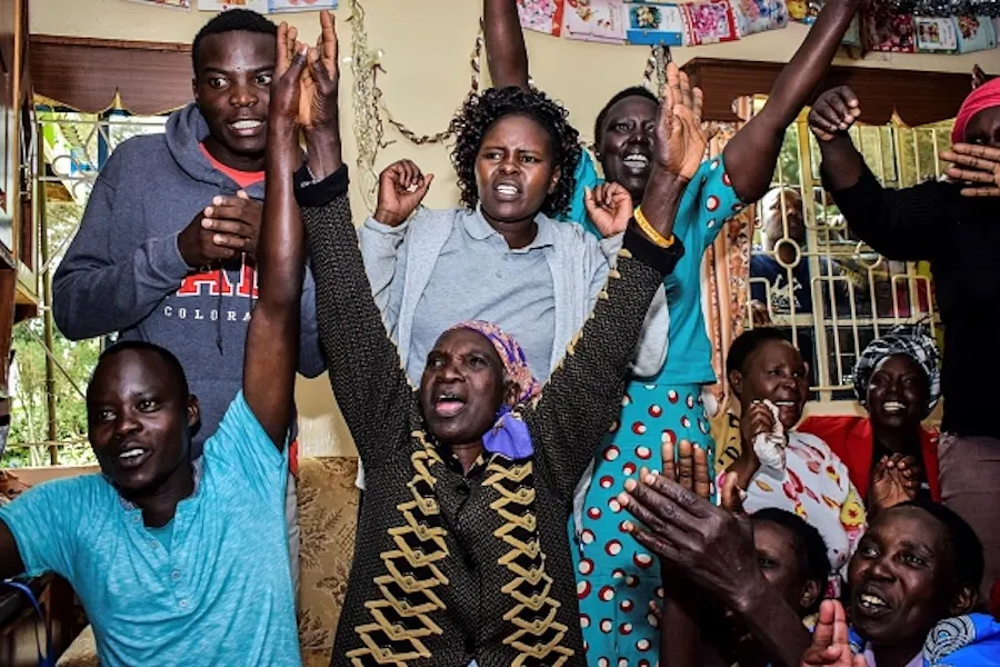 World marathon record holder Eliud Kipchoge's mother, Janet Rotich (C) watches a television broadcast on October 12, 2019, with relatives at her home in Kapsisisywa. ?w=200&h=150