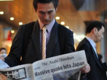 A man reads the Asahi Shimbun breaking news edition. 