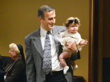 Dr. Saad Jazrawi, president of the Portland Catholic Physicians Guild, holds daughter Samar, age 7 months, during a dinner following the annual White Mass for Catholic health care workers in 2019. “If I combine my faith and my work, I’m a better Catholic and a better physician,” said Jazrawi.