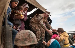 Jordanian troops and UNHCR officials help bring Syrian refugees to Jordan's Zaatari refugee camp.   Lucian Perkins for the US Holocaust Memorial Museum.