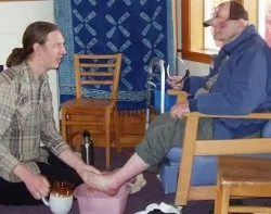 L'Arche volunteer washes the feet of a community resident. ?w=200&h=150