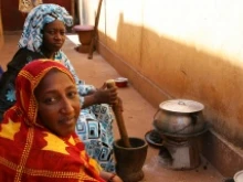 (L-R) Fatimata Toure and her sister Hawa prepare a meal at their relatives' home in Bamako, Mali. Photo by Helen Blakesley/Catholic Relief Services.