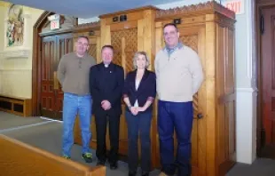 (L-R) Timothy Conlon, Fr. Janusz Kukulka, Lisa Knott and her husband Patrick, stand in front of the refurbished confessional.   Jack Sheedy/The Catholic Transcript.