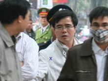Le Quoc Quan is escorted by police. 