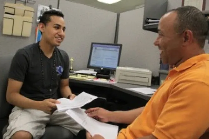 Luis Peralta R assists Luis Lucario L 19 complete the paperwork required by USCIS to apply for Deferred Action Credit Rick Snizek Rhode Island Catholic CNA500 US 9 13 12