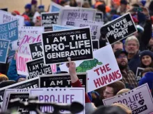Students and other participants hold signs at the 2020 March for Life in Washington, DC, on Jan. 24, 2020. 