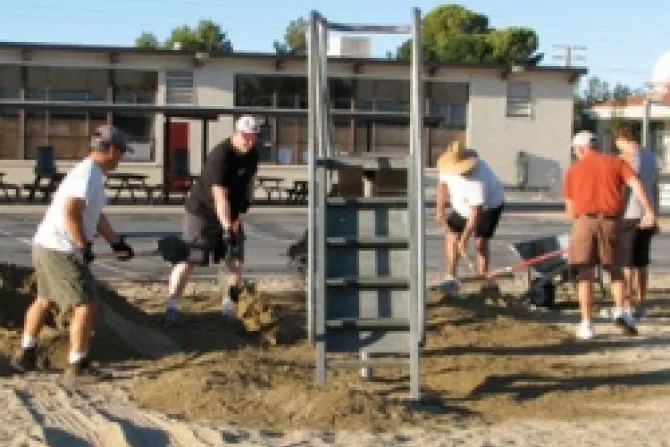 Members of Council 3199 in Ridgecrest CA spread new sand at the playground at St Ann School to ensure that the area meets local and state safety standards Credit KofC CNA 6 12 12