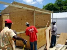 Men build transitional shelter kits in Haiti, two years after the earthquake. 