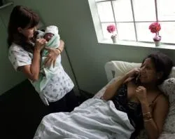 Midwife Joni McCann holds Yailin Melissa Turcios as her mother talks to relatives on Oct. 16, 2006 in Florida City, Fla. ?w=200&h=150