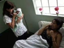 Midwife Joni McCann holds Yailin Melissa Turcios as her mother talks to relatives on Oct. 16, 2006 in Florida City, Fla. 