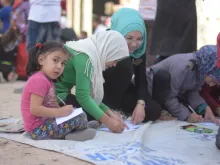 Muslim and Christian children prepare appeals for peace at a gathering in Aleppo, Syria, Oct. 4, 2016. 