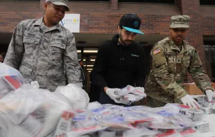National Guard members hand out food to residents near a one-mile radius "containment area" set up to halt coronavirus March 12, 2020 in New Rochelle, New York.   Spencer Platt/Getty Images.
