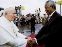 Nelson Mandela greets Pope John Paul II on his arrival at the airport in Johannesburg on September 16, 1995. 