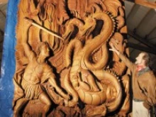 Skip Armstrong stands by a 16-foot-tall door he carved / Photo 