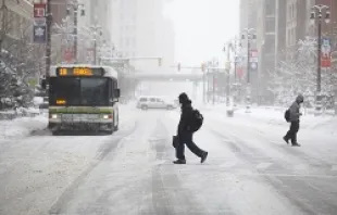 Caption: Pedestrians cross Woodward Avenue as it snows as the area deals with record breaking freezing weather January 6, 2014 in Detroit, Michigan.   Joshua Lott/Getty Images News/Getty Images.