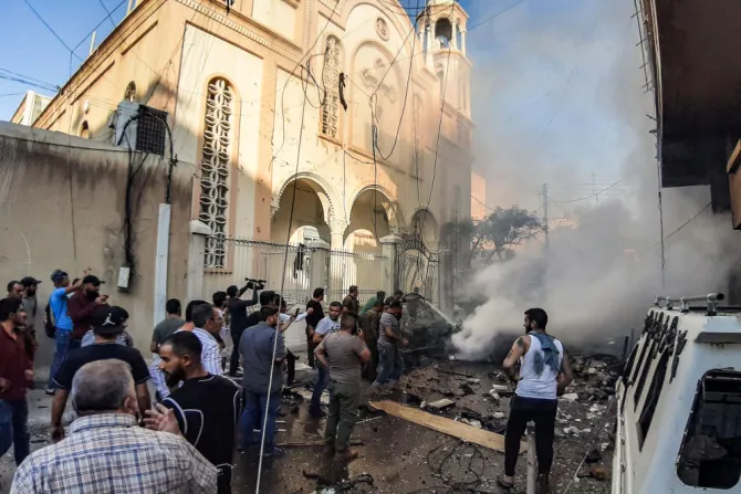People extinguish a fire at the scene of a car bomb explosion outside the Syriac Orthodox Church of the Virgin Mary in Qamishli Syria July 11 2019 Credit Gihad Darwish AFP Getty Images