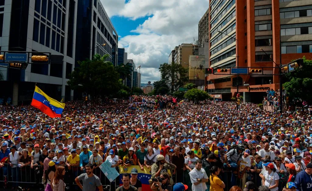 People listen to Venezuela's National Assembly head Juan Guaido (out of frame) during an opposition rally against Nicolas Maduro in Caracas, Jan. 23, 2019. ?w=200&h=150