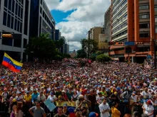 People listen to Venezuela's National Assembly head Juan Guaido (out of frame) during an opposition rally against Nicolas Maduro in Caracas, Jan. 23, 2019. 