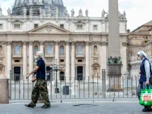 People pass in front of St. Peter’s Basilica at the end of May 2020. 