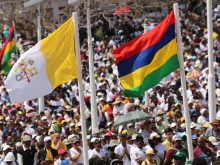 People wave flags during Mass with Pope Francis in Port Louis, Mauritius Sept. 9, 2019.