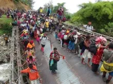 The pilgrims cross a damaged bridge near Dei, Papua New Guinea. 