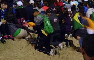 Pilgrims kneel during Stations of the Cross at World Youth Day in Rio de Janeiro, Brazil, July 26, 2013.   Michelle Bauman/CNA.