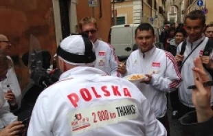 Polish pilgrims who ran to Rome for the April 27, 2014 canonizations of John Paul II and John XXIII pause for lunch after the Mass.   Alan Holdren/CNA.