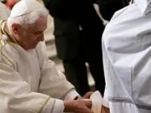 Pope Benedict kneels for the ritual washing of the feet