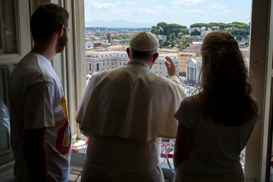 Pope Francis with two World Youth Day volunteers looks over St. Peter's Square July 26, 2015.  L'Osservatore Romano
