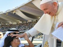 Pope Francis blesses a child at the Feb. 5, 2019 Mass in Abu Dhabi. 