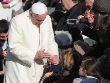 Pope Francis blesses a rosary for a pilgrim in St. Peter's Square during the Wednesday general audience on Dec. 4, 2013 