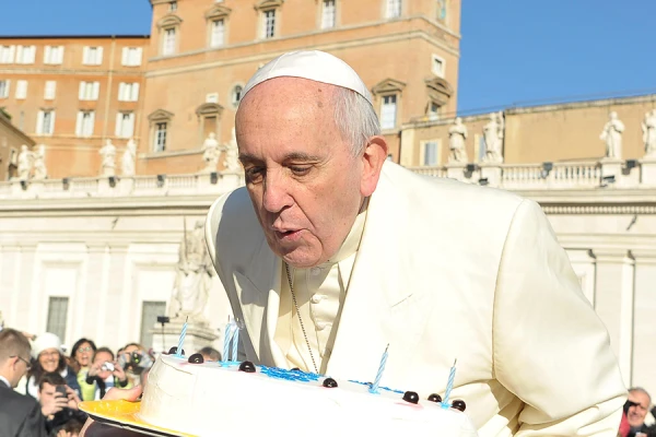 Pope Francis blows out candles on a cake for his 78th birthday in St. Peter's Square during his Wednesday general audience on Dec. 17, 2014. . ANSA / L'OSSERVATORE ROMANO