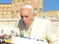 Pope Francis blows out candles on a cake for his 78th birthday in St. Peter's Square.