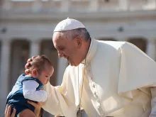 Pope Francis embraces a baby during the general audience in St. Peter's square on Aug. 26, 2015. 